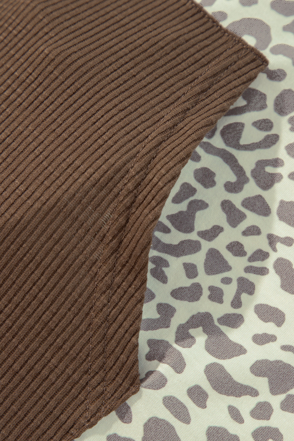 Detailed view of Leopard Ribbed Patchwork Drawstring Hoodie, highlighting its stylish cut and fit.